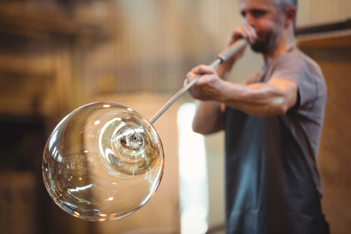 glassblower shaping glass blowpipe