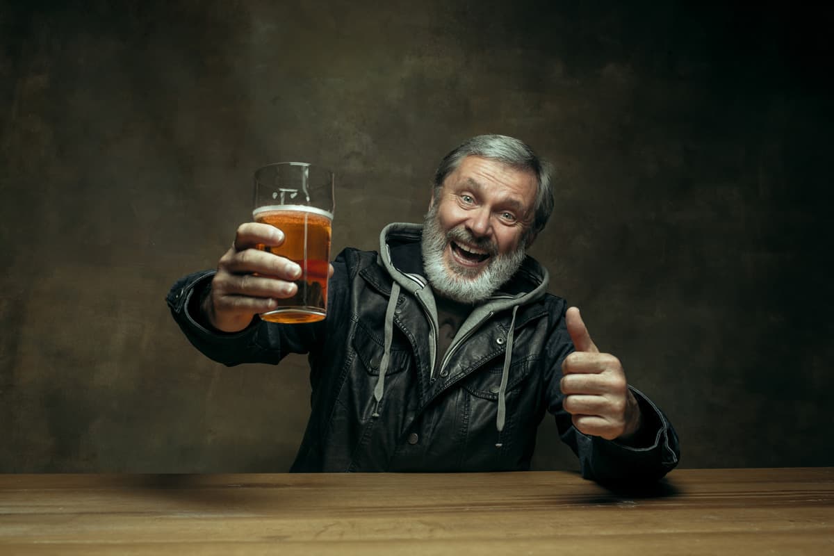 smiling bearded male drinking beer in pub - beer styles