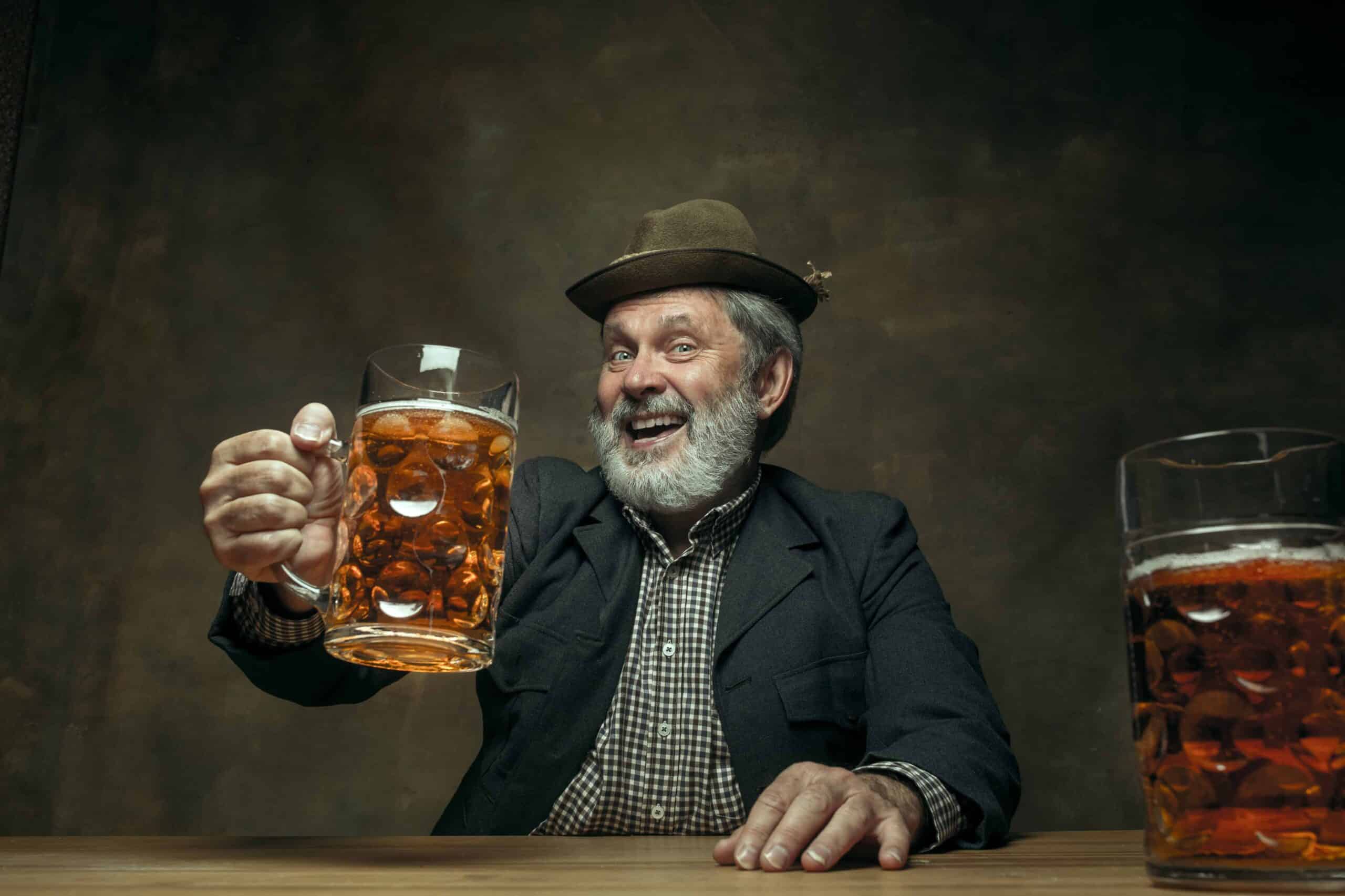 smiling bearded male drinking beer in pub
