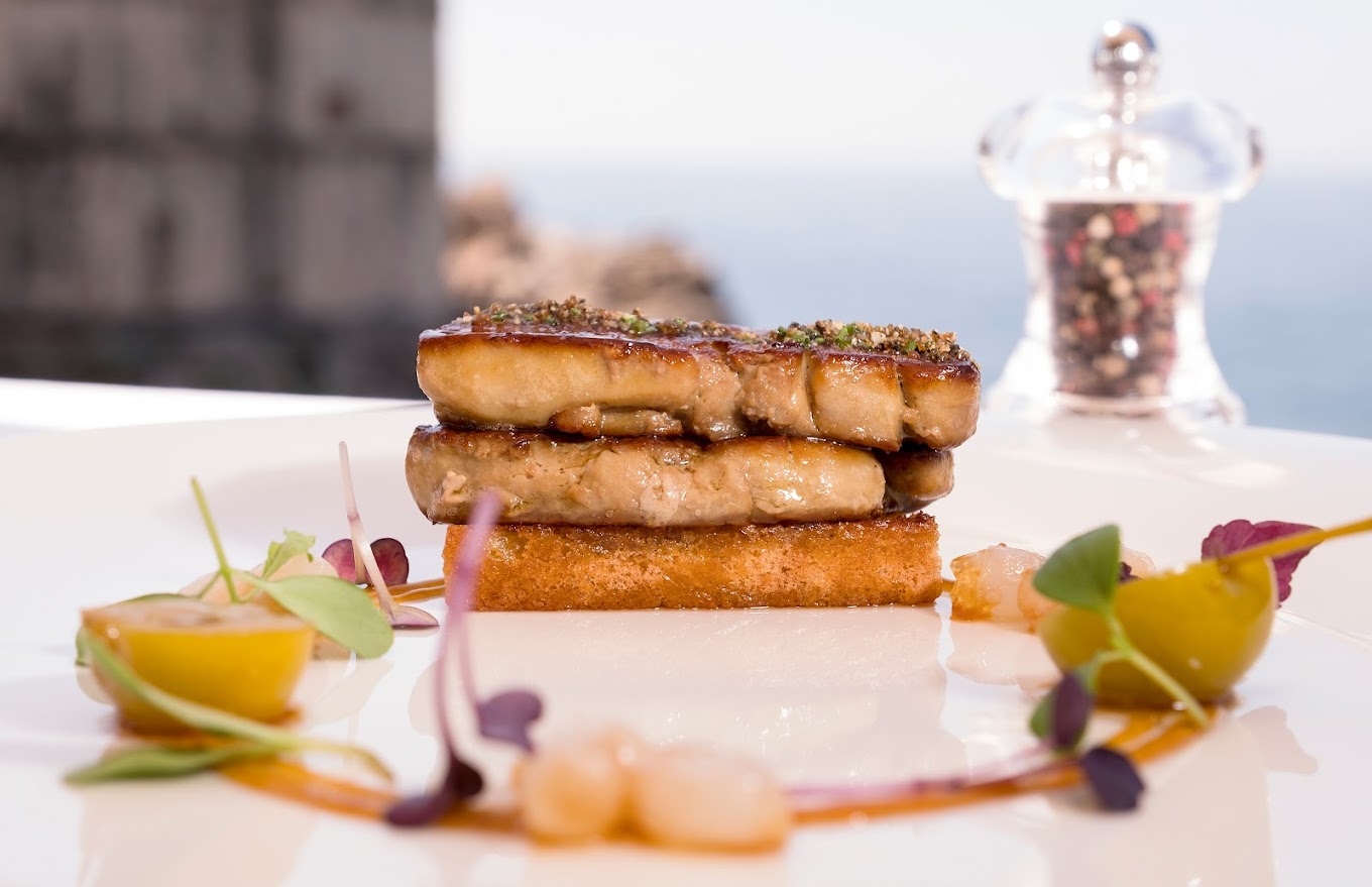 Image of beautifully served tuna steak with panoramic view of Old Town Dubrovnik and sea from restaurant Nautika 