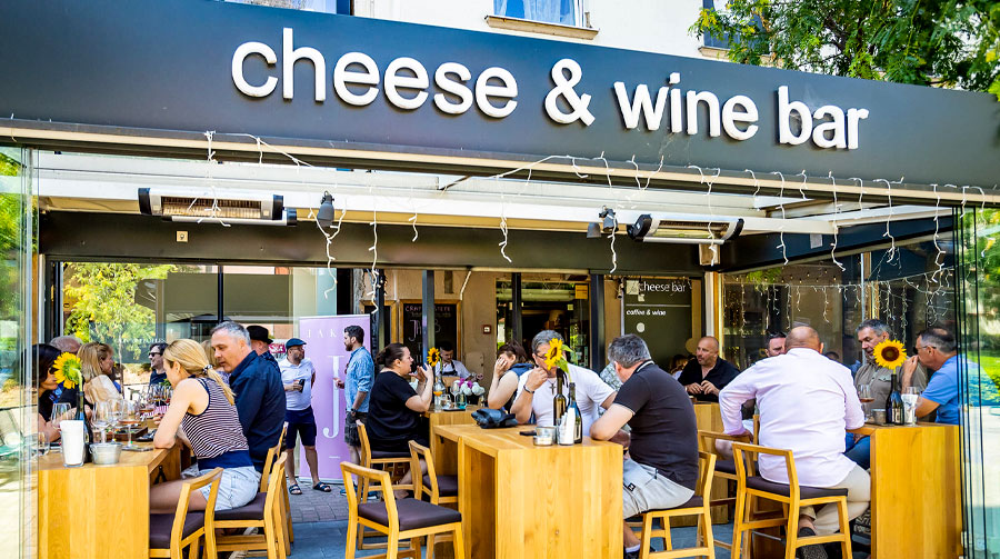 Image of outdoor terrace where people enjoy a wine tasting and charcuteries of Cheese Bar