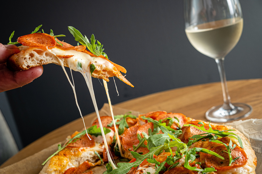 Image of pizza and glass of wine on a wooden table