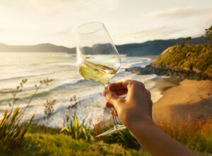 Image of a Sauvignon Blanc wine in a glass with panoramic beach and sea view