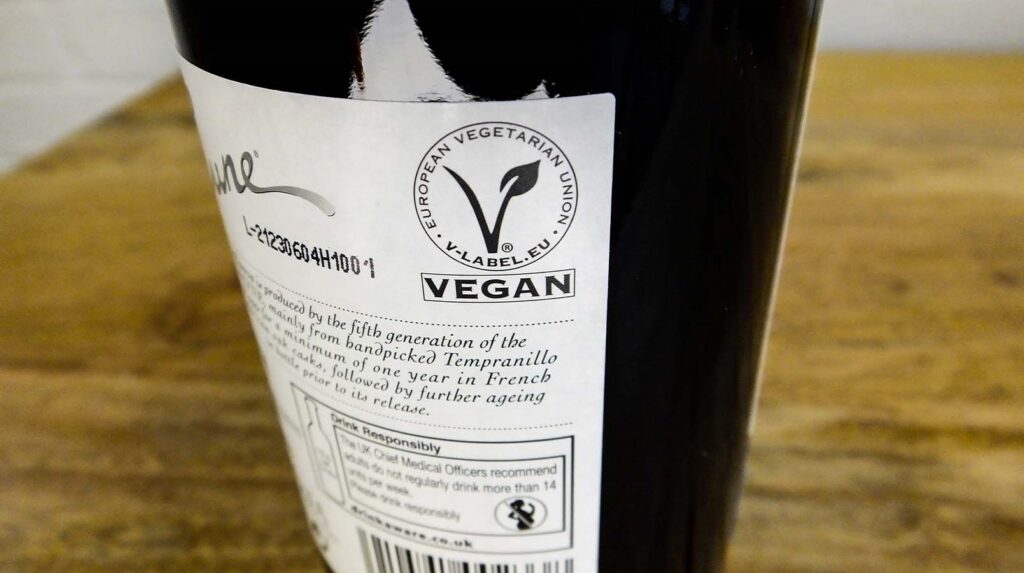 Image of a bottle and a label certification of vegan wine