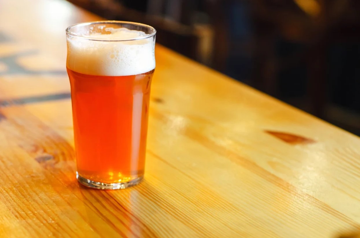 Image of a glass of Pale Ale beer on the wooden table