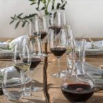 Image of a table set for dinner with two sets of Riedel wine glasses