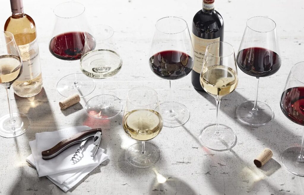 Image of various wine glasses with bottles of wine